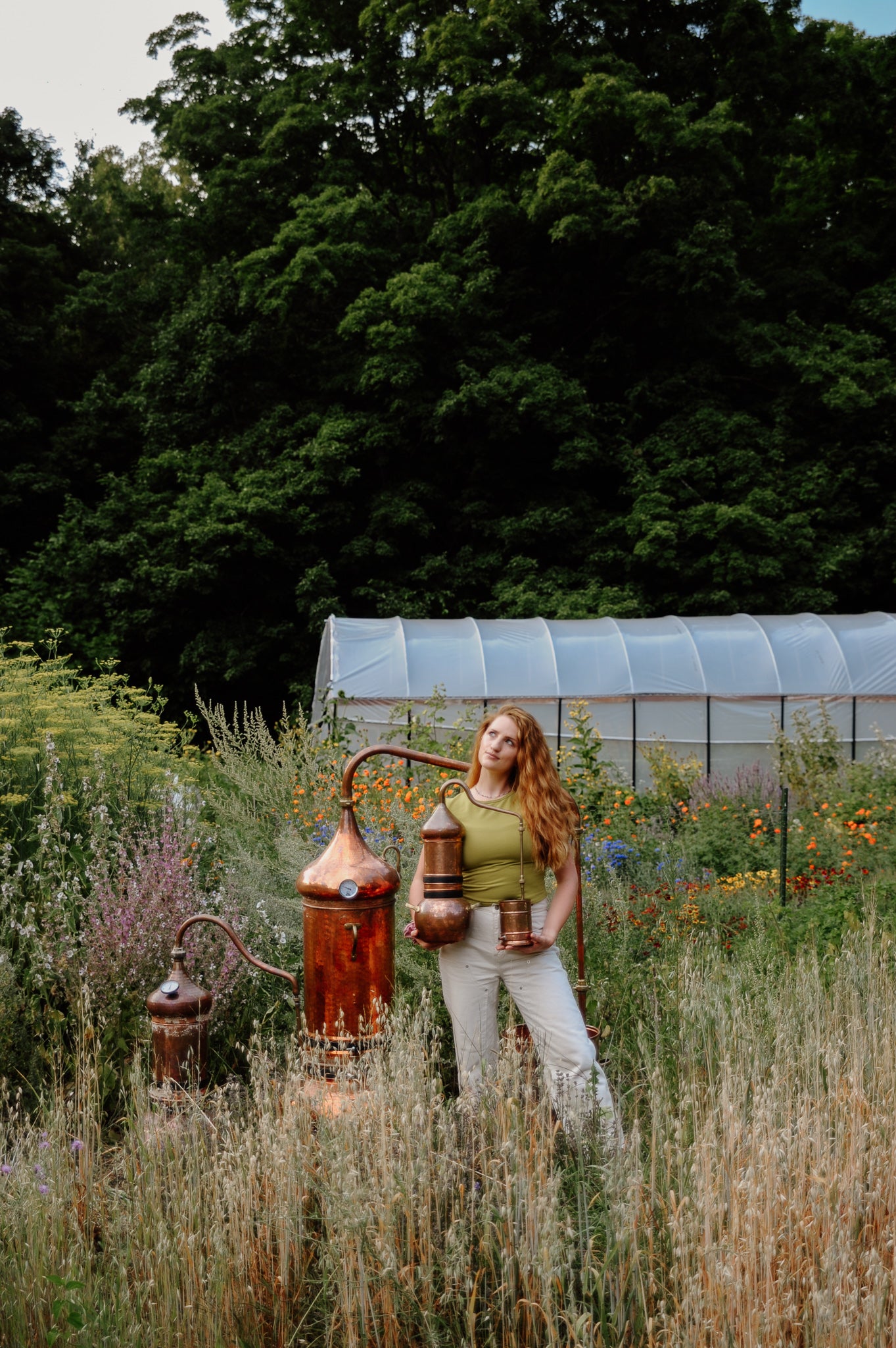 Woman standing in a garden with copper stills