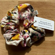 Botanically dyed hemp-silk scrunchie with a label on a wooden surface